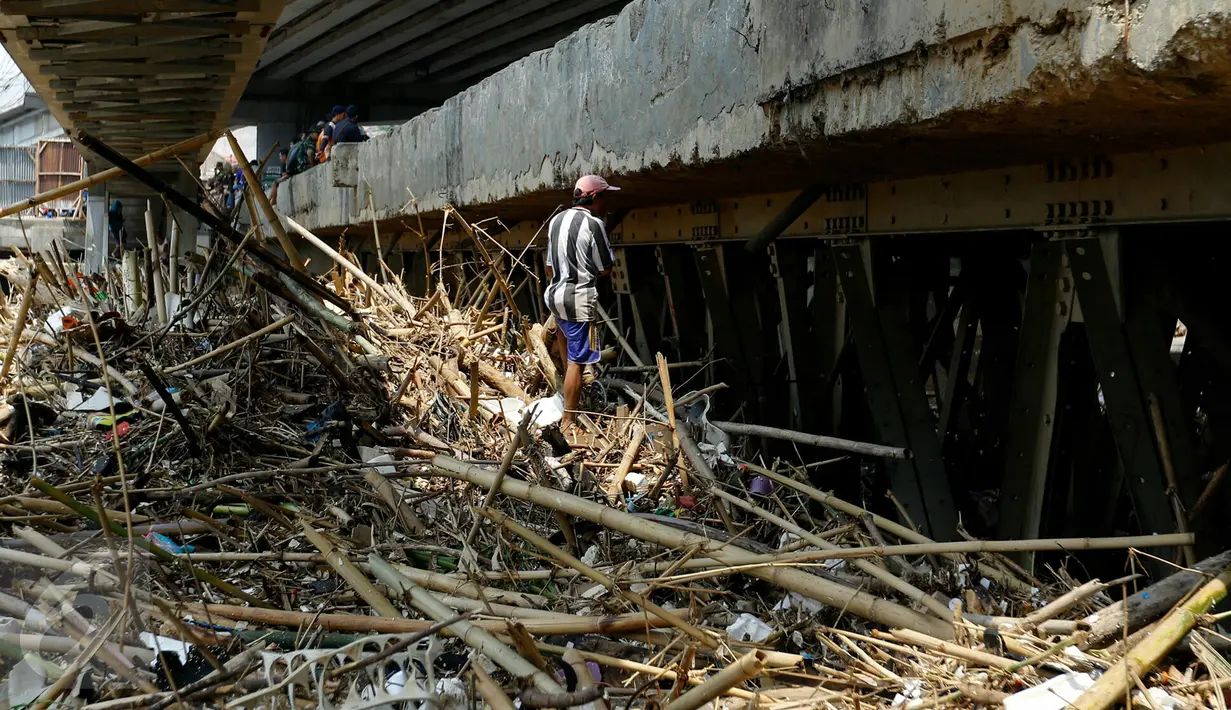 Pemulung mencari sampah plastik di sela-sela tumpukan sampah di aliran sungai Ciliwung tepat bawah fly over Kalibata, Jakarta, (16/11/2015). Pasca datangnya air kiriman dari Bogor, tumpukan sampah menumpuk di bawah jembatan. (Liputan6.com/Yoppy Renato)