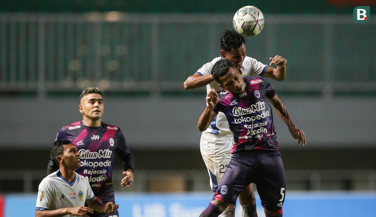 Pemain PSIM Yogyakarta, Syarif Wijianto (atas) berebut bola dengan pemain Rans Cilegon FC, Saddam Hi Tenang dalam laga semifinal Liga 2 2021 di Stadion Pakansari, Bogor, Senin (27/12/2021). (Bola.com/Bagaskara Lazuardi)