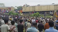 Warga menyaksikan tim penyelamat bekerja setelah kecelakaan kereta, tabrakan antara kereta kargo dan Kanchanjunga Express (kereta penumpang), dekat stasiun New Jalpaiguri, Benggala Barat, India, Senin, 17 Juni 2024. (AP Photo/Diptendu Dutta)