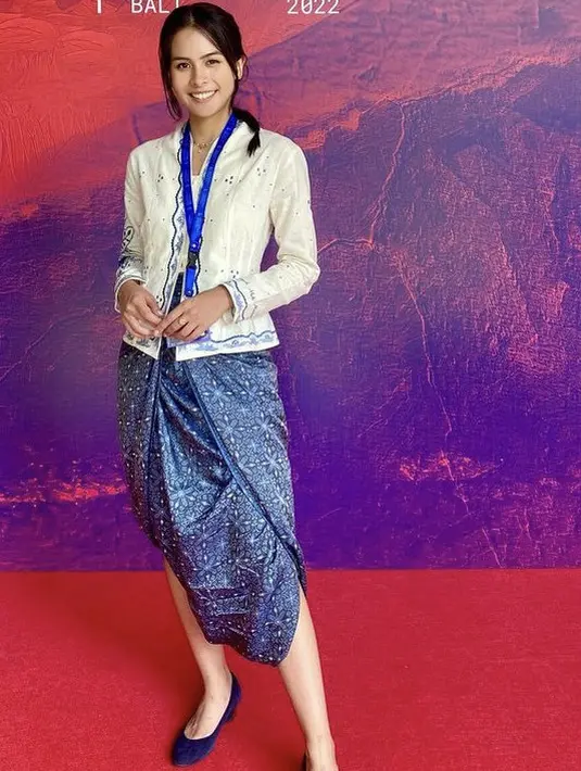 Maudy Ayunda tampil mengenakan kebaya putih lengan panjang yang dipadukan kain lilit warna biru. [Instagram/@maudyayunda]