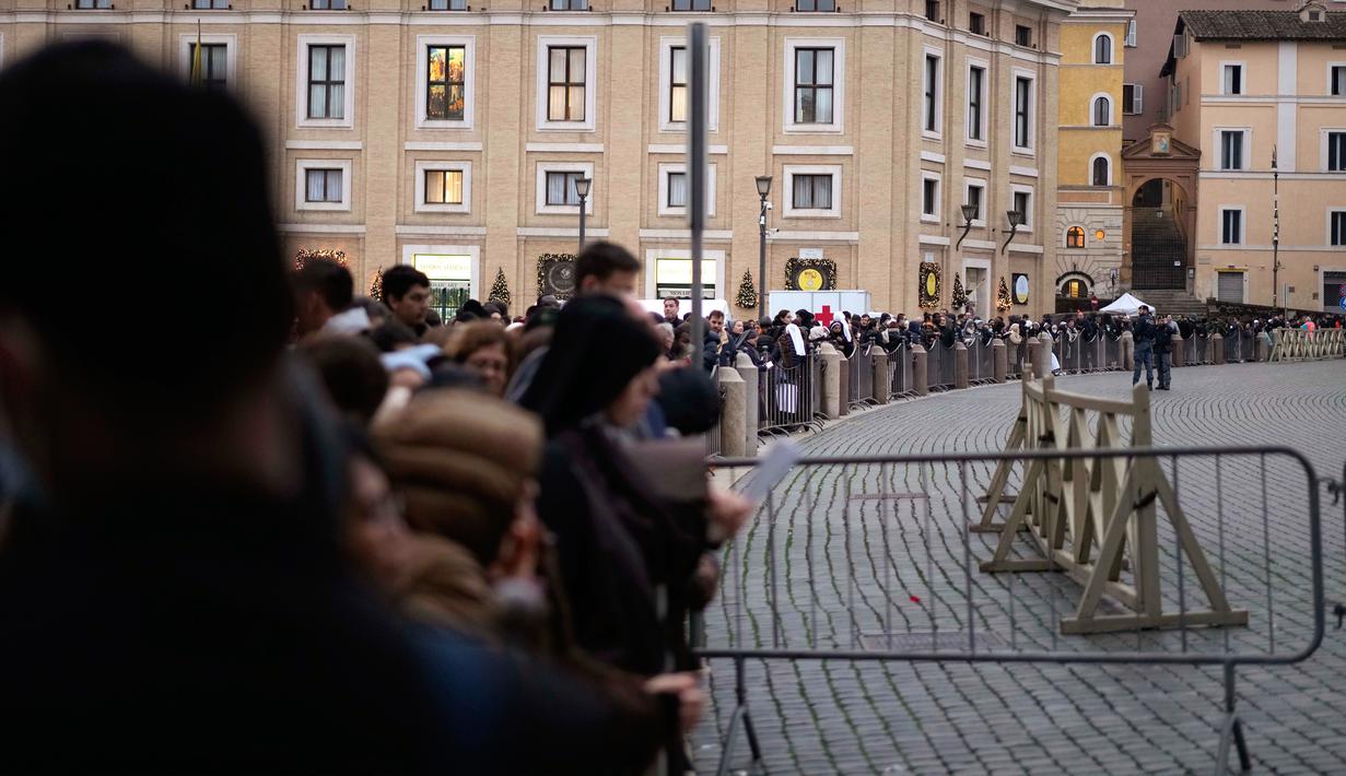 Orang-orang mengantre untuk memasuki Basilika Santo Petrus tempat mendiang Paus Emeritus Benediktus XVI disemayamkan di Vatikan, Senin (2/1/2023). Benediktus XVI, teolog Jerman yang akan dikenang sebagai paus pertama dalam 600 tahun yang mengundurkan diri, telah meninggal pada 31 Desember 2022 di usia 95 tahun. (AP Photo/Andrew Medichini)