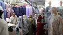 Pedagang melayani pembeli perlengkapan ibadah di Pasar Tanah Abang Blok A, Jakarta, Senin (4/4/2022). Penjualan busana muslim seperti mukena, kerudung, sajadah dan sarung mengalami peningkatan di bulan Ramadhan. (Liputan6.com/Faizal Fanani)