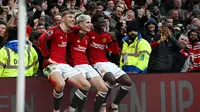 Tiga pemain Manchester United, Rasmus Hojlund, Alejandro Garnacho, dan Kobbie Mainoo duduk di atas papan iklan lapangan Old Trafford sebagai bentuk selebrasi gol yang dicetak ke gawang West Ham United dalam laga pekan ke-23 Premier League 2023/2024, Minggu (4/2/2024) malam WIB. (Paul ELLIS / AFP)