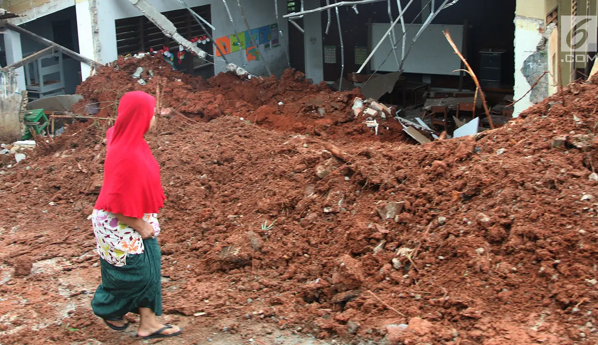 Warga melihat kondisi kelas SDN Bambu Apus 1 usai tertimpa truk pengangkut tanah proyek Tol Cinere-Serpong di Kelurahan Bambu Apus, Kecamatan Pamulang, Tangerang Selatan (14/1). Tidak ada korban jiwa akibat kejadian tersebut. (Merdeka.com/Arie Basuki)
