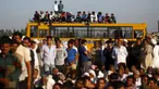 Sejumlah orang duduk di bus sekolah saat memblokir jalan dalam demonstrasi di negara bagian Haryana ke New Delhi, India,Minggu (21/2). Demonstrasi dan aksi kekerasan akibat kelangkaan air di wilayah tersebut menewaskan 10 orang. (REUTERS/Adnan Abidi)