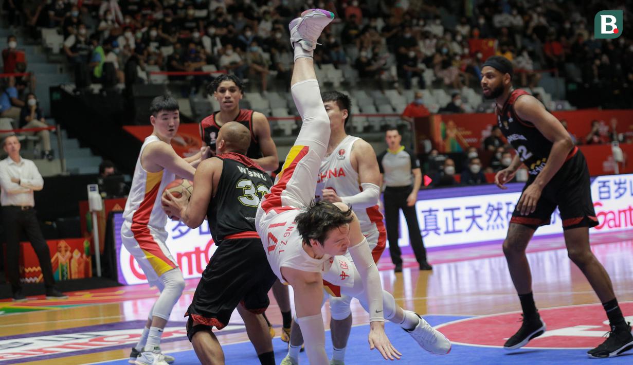 Pemain Timnas Basket China, Wang Zhelin (tengah) terjatuh saat laga playoff perempat final FIBA Asia Cup 2022 antara Timnas Basket China melawan Timnas Basket Indonesia di Istora Senayan, Jakarta, Senin (18/07/2022). (Bola.com/Bagaskara Lazuardi)