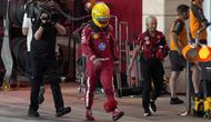 Pembalap Ferrari asal Inggris, Lewis Hamilton (tengah), berjalan di jalur pit selama sesi kualifikasi sprint menjelang Grand Prix Formula Satu Qatar di Sirkuit Internasional Lusail pada 28 November 2025. (Altaf Qadri/ POOL/AFP)