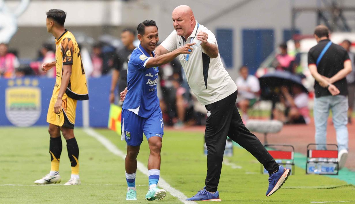 Berkat hasil ini, Persib kini mengemas 38 poin atau satu angka unggul dari Borneo FC yang harus rela turun ke posisi dua. Sementara Persija turun ke peringkan ketiga dengan 35 poin. Tampak dalam foto, penyerang sayap kiri Persib, Beckham Putra (tengah) bersama pelatih Bojan Hodak saat pertandingan pekan ke-17 BRI Super League 2025/2026 melawan Persija di Stadion Gelora Bandung Lautan Api (GBLA), Bandung, Jawa Barat, Minggu 11 Januari 2026. (Bola.com/Abdul Aziz)