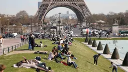 Sejumlah pengunjung sedang menikmati musim semi yang hangat dan cerah di Trocadero square di dekat menara Eiffel, Paris, Kamis (9/4/2015). (REUTERS/Charles Platiau)