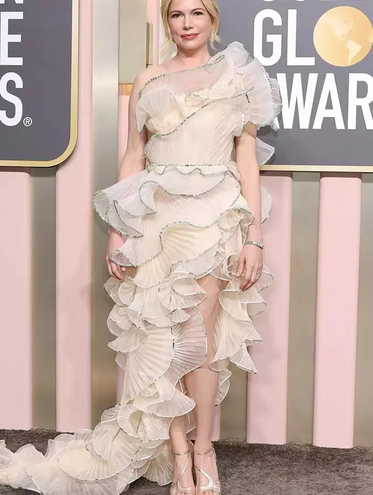 <p>Michele Williams tampil memukau dalam balutan gaun beraksen keliman metalik, ditambah platform bertali hitam dan perhiasan cantik dari Tiffany &amp; Co.. Foto: People.</p>