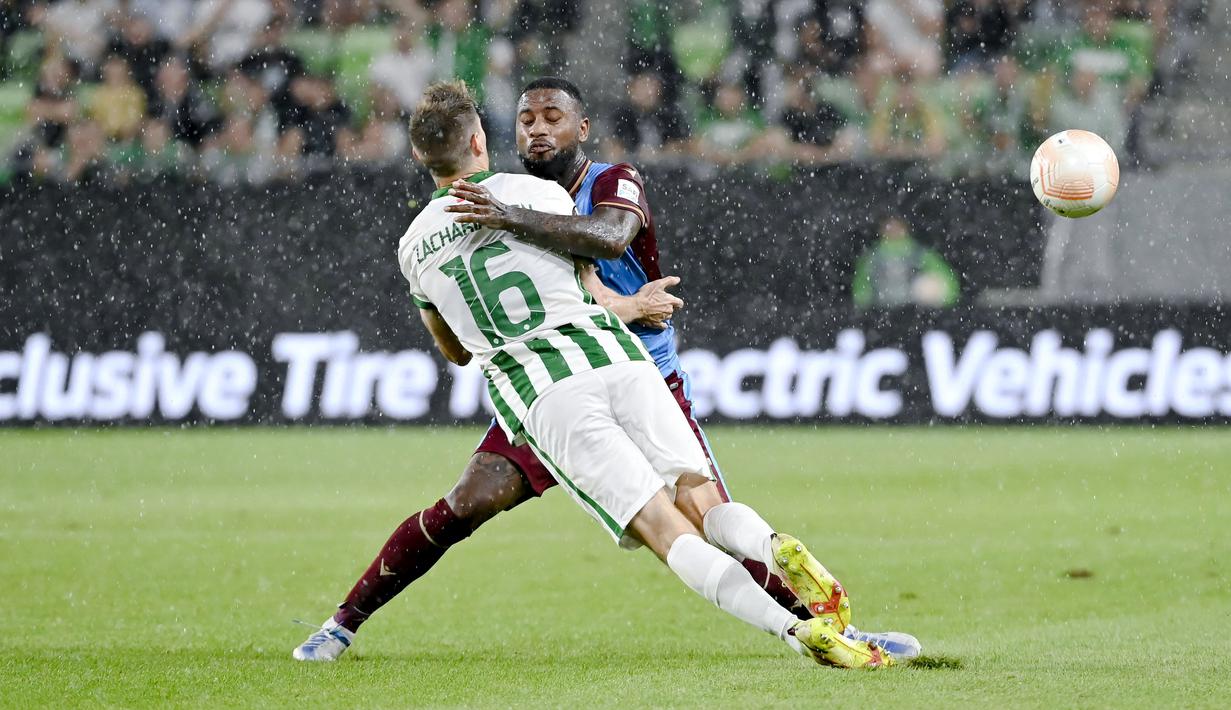 Pemain Trabzonspor, Stefano Denswil, berusaha menghadang pergerakan pemain Ferencvaros, Kristoffer Zachariassen, pada laga Liga Europa di  Groupama Arena, Jumat (9/9/2022). (Tamas Kovacs/MTI via AP)