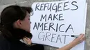 Seorang wanita mempersiapkan bahan untuk berunjuk rasa di pusat kota Miami, AS, Kamis (26/1). Pengunjuk rasa menolak kebijakan Presiden AS, Donald Trump yang membatasi warga Muslim masuk ke AS. (AP Photo / Alan Diaz)