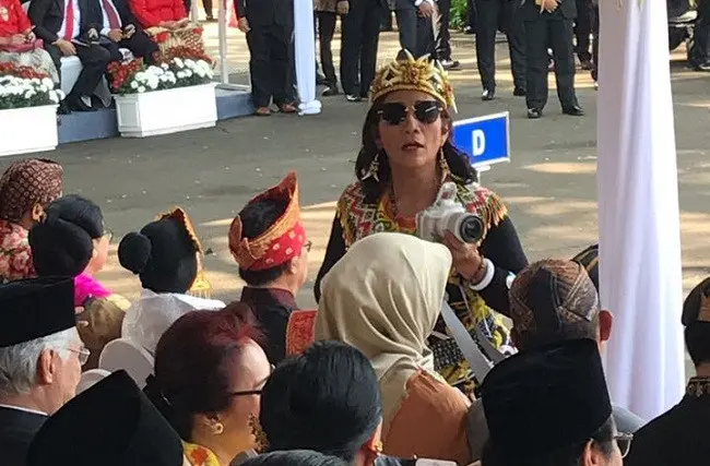 Menteri Susi Pudjiastuti tampak sibuk dengan kamera yang dibawanya saat upacara memperingati HUT ke-72 RI di Istana Merdeka. Foto: Adinda Tri Wardhani/ Liputan6.com.