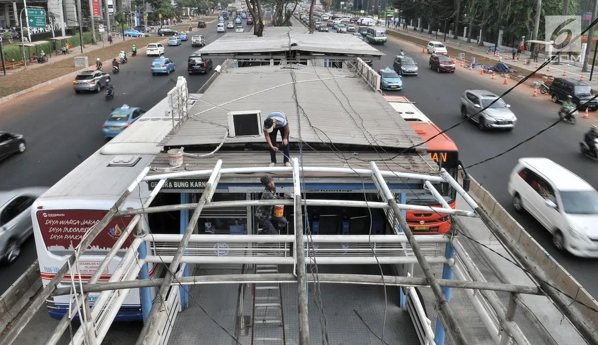 Pekerja menyelesaikan proyek perluasan Halte Bus Transjakarta GBK di Jalan Jenderal Sudirman, Jakarta, Selasa (24/7). Hal ini juga untuk mengantisipasi lonjakan penumpang akibat perluasan sistem ganjil genap selama Asian Games. (Liputan6.com/FaizalFanani)