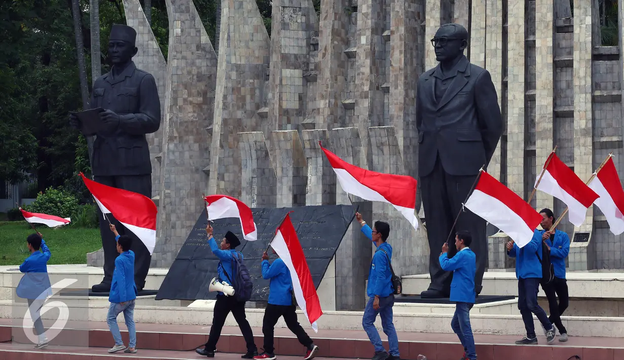 Mahasiswa mengibarkan bendera merah putih di depan Patung Soekarno - Hatta di Tugu Prooklamasi, Jakarta, Kamis (3/11). Ribuan mahasiswa ini menyatakan sikap terhadap aksi 4 November besok agar berjalan dengan damai. (Liputan6.com/Johan Tallo)