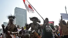 Masyarakat Papua yang merupakan mantan karyawan PT Freeport Indonesia saat melakukan penggalangan dana di tengah berlangsungnya Hari Bebas Kendaraan Bermotor atau Car Free Day di kawasan Bundaran HI, Jakarta, Minggu (5/8). (Merdeka.com/Iqbal S. Nugroho)