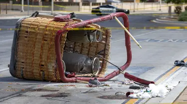 Keranjang balon udara yang jatuh tergeletak di trotoar di Albuquerque, New Mexico, Amerika Serikat, Sabtu (26/6/2021). Polisi mengatakan lima penumpang tewas setelah jatuh di jalan yang ramai. (AP Photo/Andres Leighton)