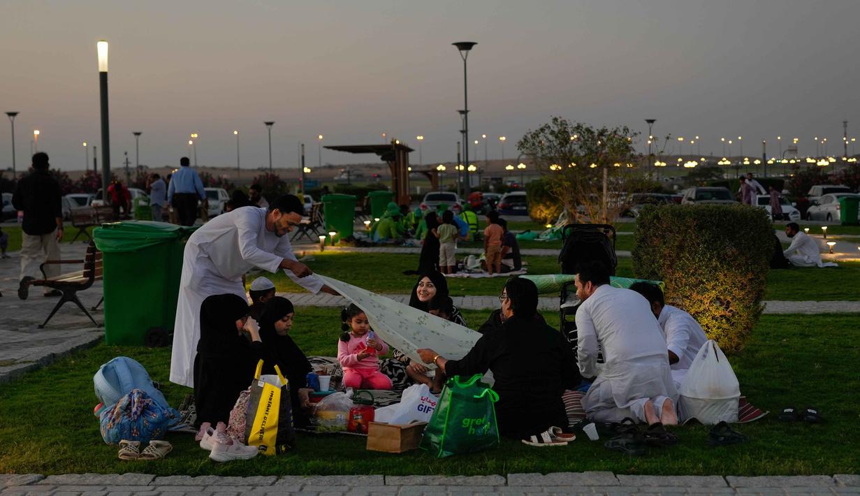 Masjid ini memiliki halaman pekarangan yang sangat luas. Tampak dalam foto, sebuah keluarga Muslim bersiap untuk berbuka puasa selama bulan suci Ramadan di Masjid Agung Sharjah, dekat Dubai, Uni Emirat Arab, Jumat 27 Februari 2026. (AP Photo/Altaf Qadri)