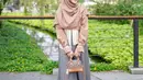 Melengkapi penampilannya, Anisa mengenakan hijab warna coklat muda, flat shoes, dan mini bag warna senada. (Instagram/anisarahma_12).