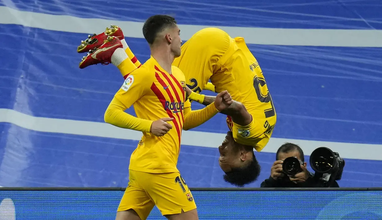 Pemain Barcelona Pierre-Emerick Aubameyang (kanan) melakukan selebrasi usai mencetak gol ke gawang Real Madrid pada pertandingan sepak bola La Liga Spanyol di Stadion Santiago Bernabeu, Madrid, Spanyol, Minggu (20/3/2022). Barcelona menang 4-0. (AP Photo/Manu Fernandez)