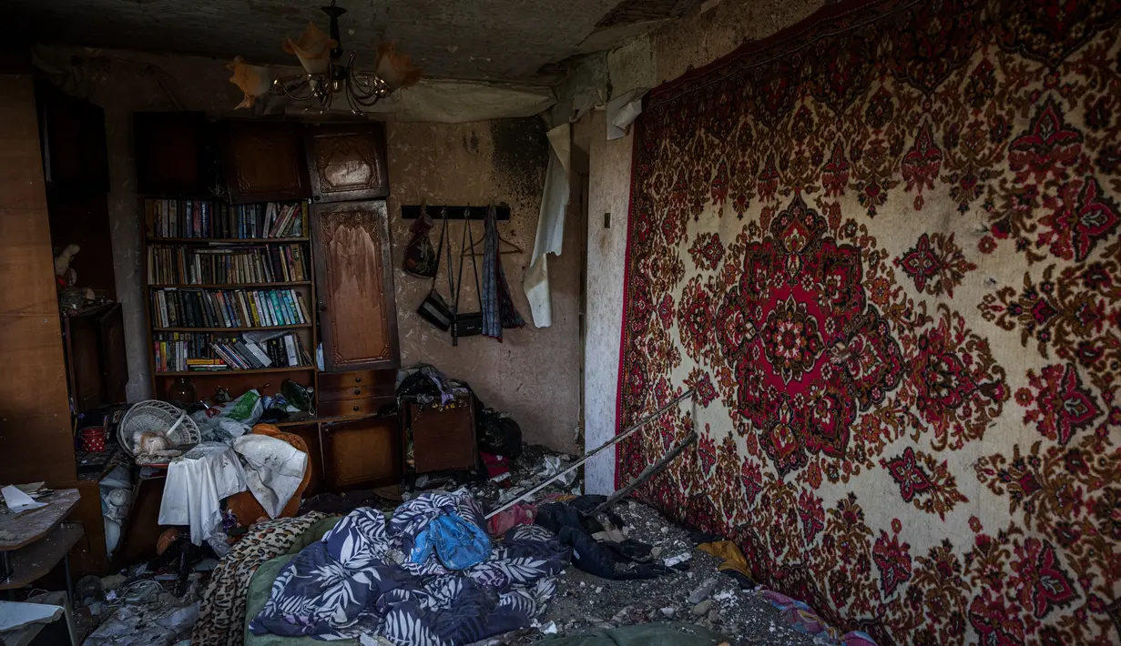 <p>Sebuah foto menunjukkan interior rumah yang hancur, di tengah invasi Rusia ke Ukraina, di desa Vilkhivka, dekat kota timur Kharkiv, pada 14 Mei 2022. Puluhan rumah di Vilkhivka, sebuah desa berpenduduk sekitar 2.000 jiwa, hancur oleh peluru, ledakan atau kebakaran. Puing-puing berserakan di jalan-jalan termasuk selongsong peluru, dan sisa-sisa amunisi. (Dimitar DILKOFF / AFP)</p>