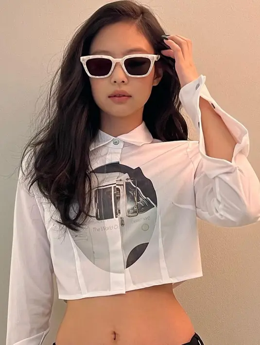 Tampil dalam kemeja model crop top berwarna putih, wanita 26 tahun ini pun terlihat menggunakan kacamata dengan model yang cukup unik. Bingkai putih dengan corak serta lensa hitam membuat penampilannya terlihat menawan. (Liputan6.com/IG/@jennierubyjane)