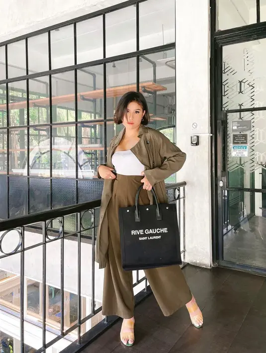 Setelan outer dan celana kulot dengan warna dark olive serta dalaman kaos putih ini sedang trend di kalangan anak muda. Gaya simpel satu ini bisa jadi inpirasi OOTD di acara santai. (Liputan6.com/IG/@awkarin)