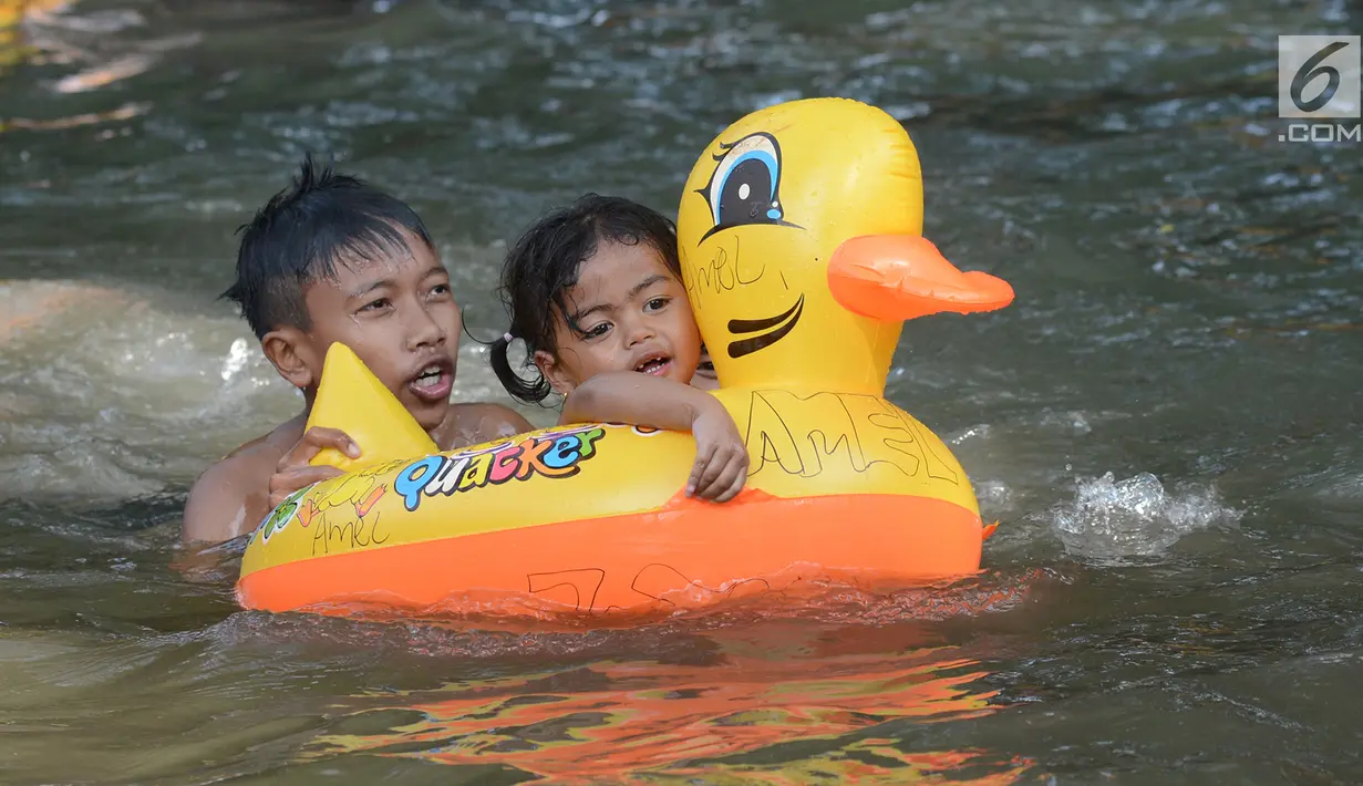Dua orang anak menggunakan pelampung bebek saat bermain air di wisata alam Mata Air Sodong di Desa Ligar Mukti, Klapanunggal, Kabupaten Bogor, Jawa Barat, Minggu (9/6). (merdeka.com/Imam Buhori)