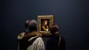 Awak media melihat lukisan "Portrait of a Musician" karya Leonardo Da Vinci di museum Louvre, Paris, Selasa (22/10/2019). Ada 160 karya dalam pameran 500 tahun wafatnya Leonardo da Vinci yang diharap dapat menarik setengah juta pengunjung saat ditutup pada 24 Februari 2020. (AP/Thibault Camus)
