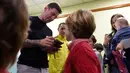 Bintang Barcelona, Lionel Messi memberikan tanda tangan untuk pasien anak-anak saat melakukan kunjungan amal di Rumah Sakit Barcelona, Senin (4/1/2016). (AFP PHOTO / Lluis GENE)