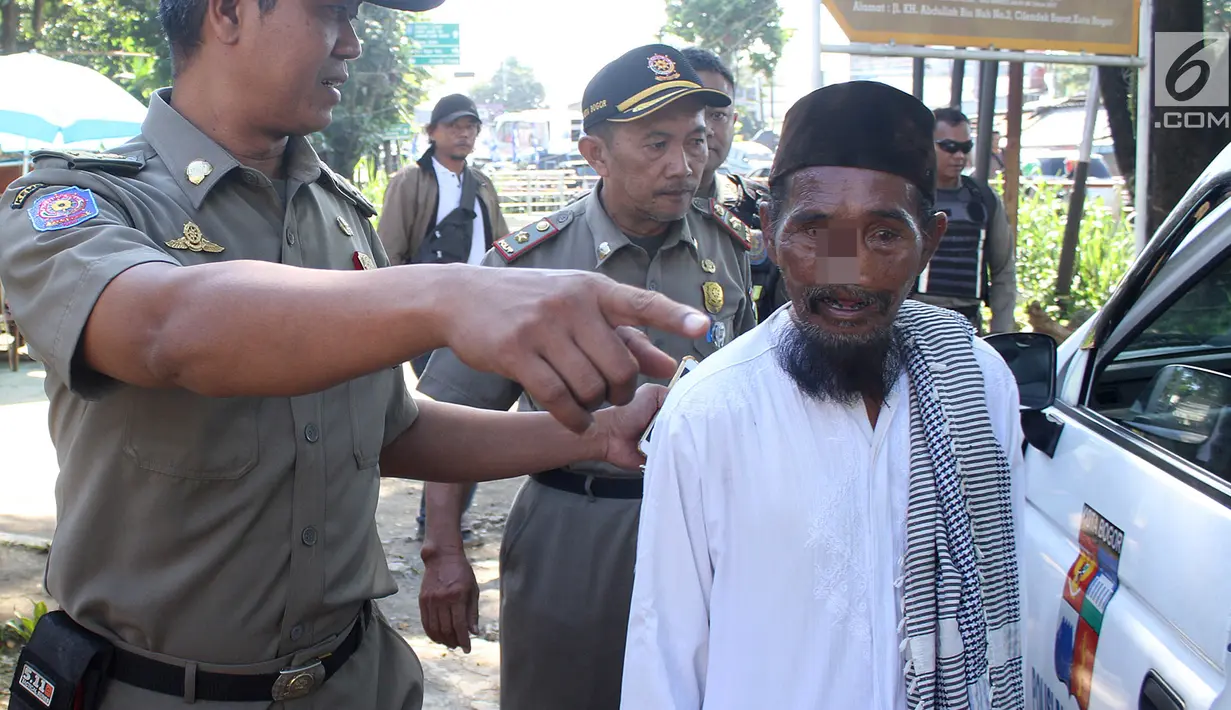 Petugas Satpol PP Kota Bogor mengamankan pengemis yang sempat viral di kawasan perempatan Yasmin, Bogor, Jawa Barat, Rabu (20/3). Pengemis tersebut mengakui jika berangkat mengemis dengan menaiki mobil, namun hanya menyewa. (merdeka.com/Arie Basuki)