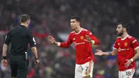 Pemain Manchester United Cristiano Ronaldo (tengah) dan Bruno Fernandes berbicara kepada wasit Stuart Attwell saat melawan Southampton pada pertandingan sepak bola Liga Inggris di Stadion Old Trafford, Manchester, Inggris, 12 Februari 2022. Pertandingan berakhir dengan skor 1-1. (AP Photo/Jon Super)