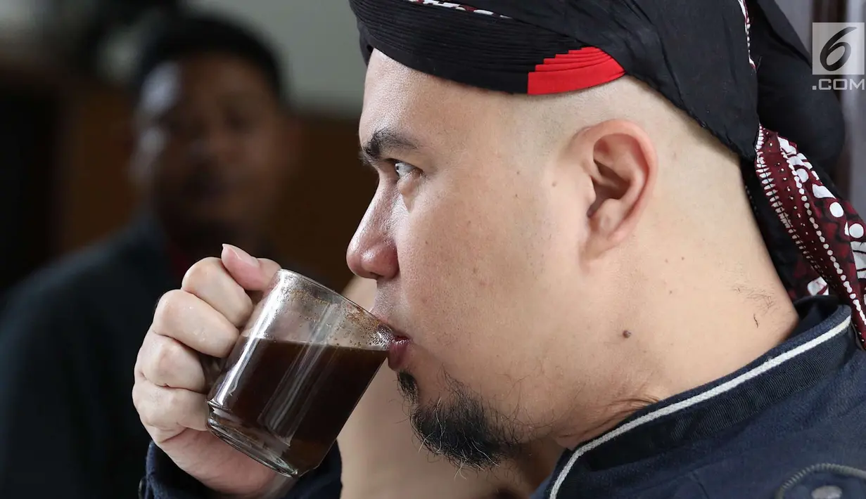 Terdakwa kasus ujaran kebencian, Ahmad Dhani meminum kopi sebelum menjalani sidang lanjutan di PN Jakarta Selatan, Senin (2/7). Sidang tersebut menghadirkan saksi dari jaksa dan saksi meringankan dari Ahmad Dhani. (Liputan6.com/Immanuel Antonius)