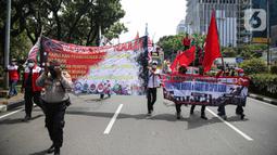 Massa buruh gabungan berjalan kaki saat menggelar aksi di kawasan Patung Arjuna Wijaya, Jakarta, Kamis (25/11/2021). Dalam aksinya, ratusan buruh tersebut menuntut pembatalan Omnibus Law Undang-Undang Cipta Kerja dan kenaikan upah 2022. (Liputan6.com/Faizal Fanani)