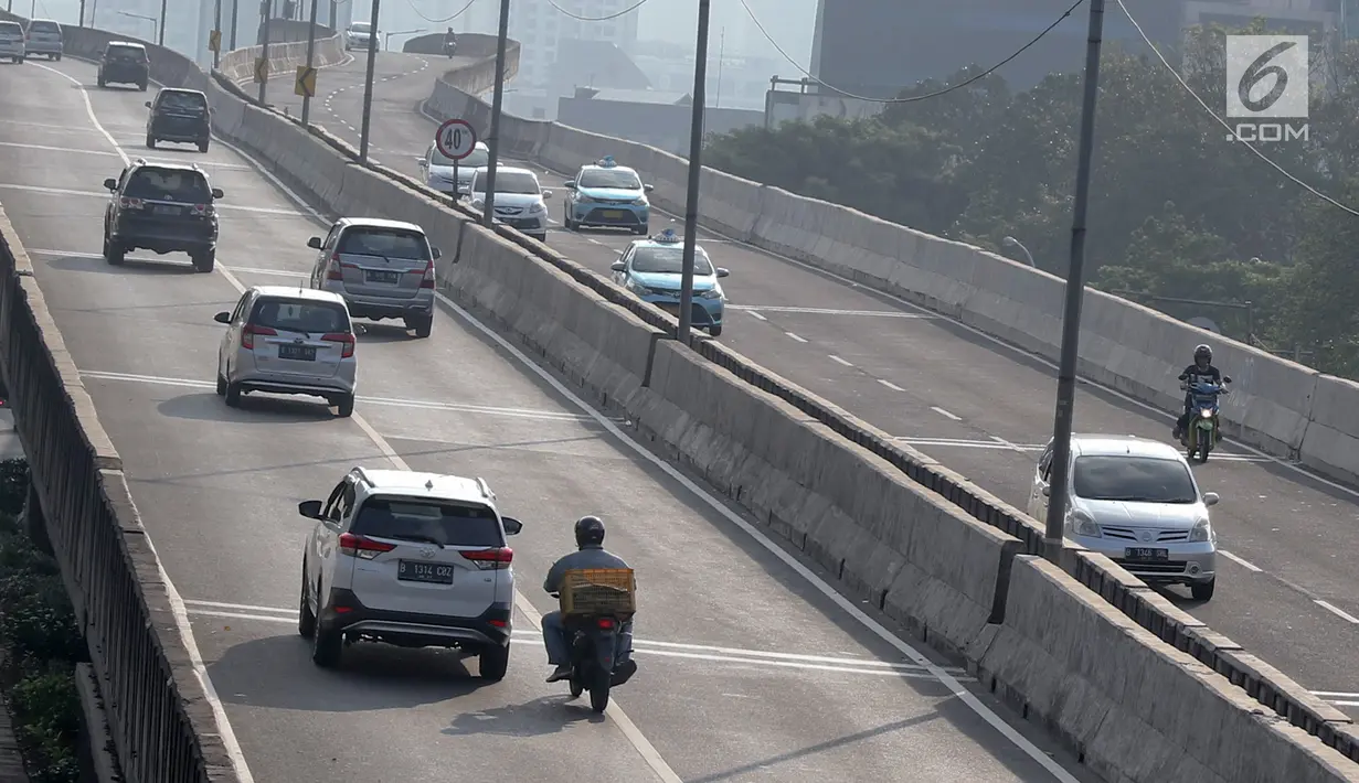 Pengendara sepeda motor melintasi Jalan Layang Non-Tol (JLNT) Kampung Melayu-Tanah Abang, Jakarta, Kamis (30/8). Meski berulang kali ditertibkan, sejumlah pemotor tetap nekat melintasi jalur khusus mobil tersebut. (Liputan6.com/Immanuel Antonius)