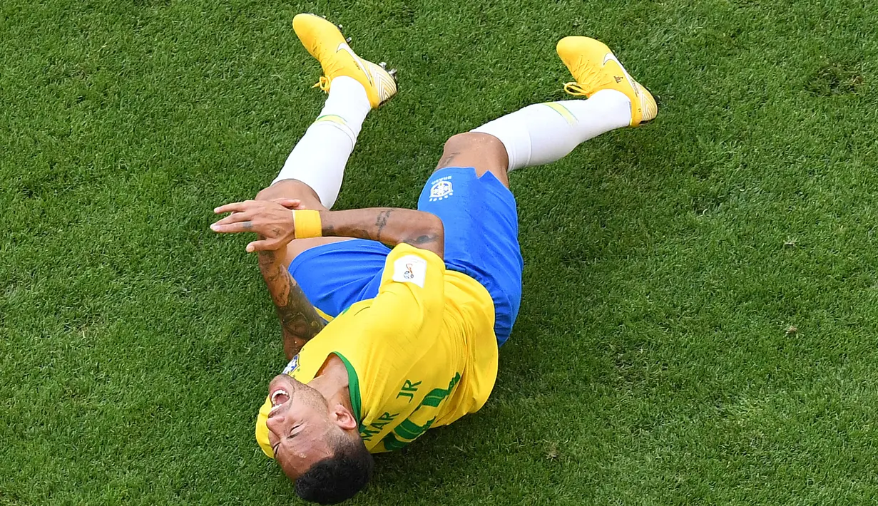Penyerang timnas Brasil, Neymar berguling di atas lapangan pada babak 16 besar Piala Dunia 2018 melawan Meksiko di Samara Arena, Senin (2/7). Neymar dituding melakukan aksi drama yang kelewatan saat berpura-pura kesakitan.  (AFP/Kirill KUDRYAVTSEV)