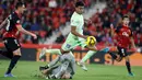 Pemain Barcelona, Lamine Yamal berusaha melewati kiper Mallorca, Leo Roman pada laga lanjutan Liga Spanyol 2024/2025 di Stadion Mallorca Son Moix, Mallorca, Spanyol, Rabu (04/12/2024) dini hari WIB. (AFP/Jaime Reina)