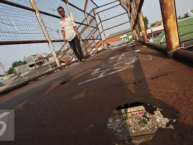 Pejalan kaki melintasi Jembatan Penyeberangan Orang (JPO) yang rusak di kawasan Tebet, Jakarta, Kamis (5/11). Kondisi jembatan yang sudah berkarat dan berlubang tersebut membahayakan pejalan kaki terutama saat malam hari. (Liputan6.com/Immanuel Antonius)