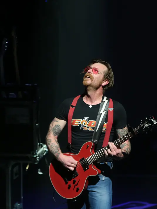 Aksi Jesse Hughes, vokalis grup rock Eagles of Death Metal, pada konser perdana mereka setelah serangan Paris pada November 2015 lalu, di gedung teater Olympia, Paris, Selasa (16/2). (AFP PHOTO/Joel SAGET)