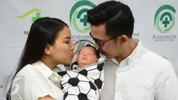 Pemain Sinetron Tya Ariestya dan suaminya Irfan mencium anak pertamanya di rumah sakit kasawan Cikini, Jakarta, Sabtu (6/8/2016). Anak pertama pasangan Tya dan Irfan diberi nama Muhammad Irfan Ratinggang.( Liputan6.com/Herman Zakharia)