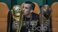 Gelandang Arema FC, Felipe Bertoldo, mencium piala saat merayakan keberhasilan meraih Piala Presiden 2017 di ruang ganti pemain. (Bola.com/Vitalis Yogi Trisna)