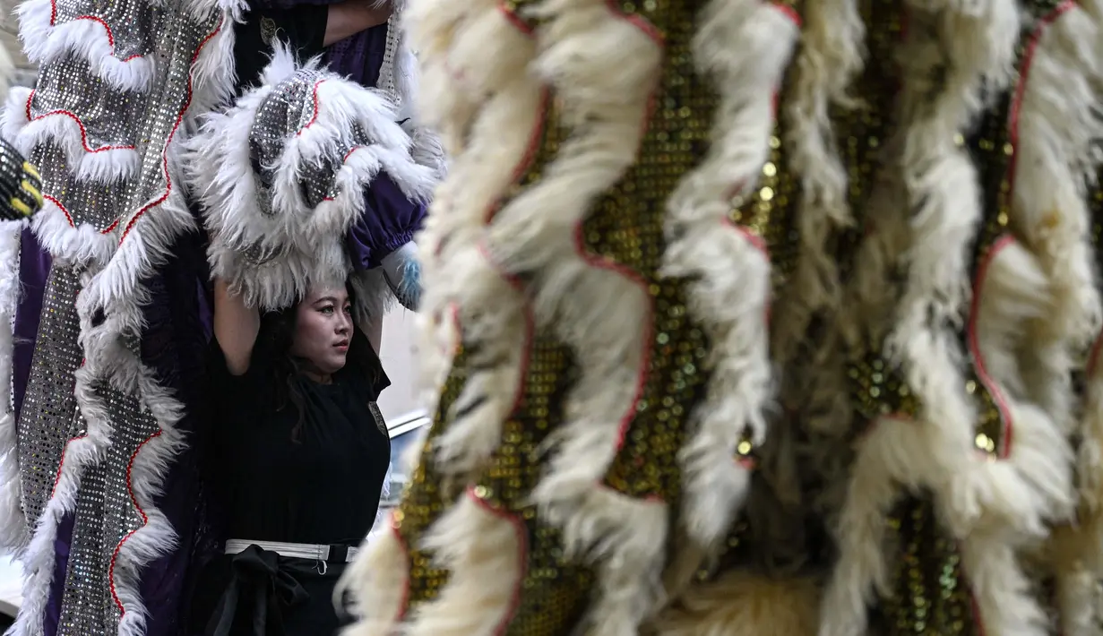 Foto yang diambil pada tanggal 23 Januari 2025 ini menunjukkan penari barongsai wanita, Lin Xinmeng sedang melakukan pertunjukan di sebuah jalan di Shantou, provinsi Guangdong, Tiongkok selatan. (Jade GAO/AFP)