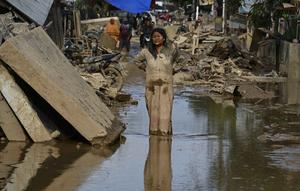 Kementerian Kesehatan sudah mengeluarkan peringatan adanya potensi lonjakan dua penyakit pasca bencana banjir bandang dan tanah longsor di Aceh, yaitu Demam Berdarah Dengue (DBD) dan Leptospirosis. Tampak dalam foto, seorang perempuan berlumuran lumpur berdiri di jalanan yang dipenuhi lumpur setelah banjir bandang melanda daerah tersebut di Aceh Tamiang, Provinsi Aceh, pada Sabtu 6 Desember 2025. (YT HARIONO/AFP)