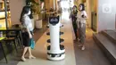 Pengunjung befoto dengan robot bernama “Bellabot” di Tangcity Mal, Kota Tangerang, Rabu (27/10/2021). Robot itu bertugas sebagai pramusaji guna meminimalisir sentuhan langsung antara pegawai dan pengunjung di saat aktivitas mal mulai beroperasi dalam masa pandemi. (Liputan6.com/Angga Yuniar)