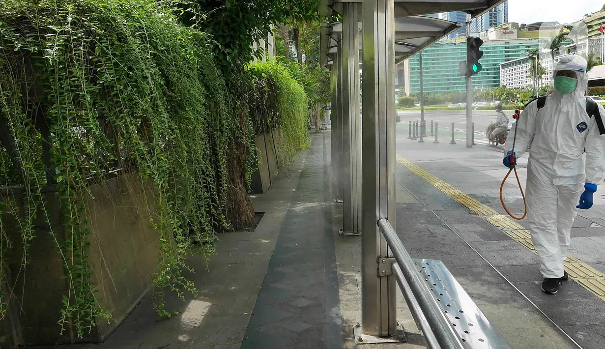 Petugas PMI DKI Jakarta melakukan penyemprotan cairan disinfektan di halte bus kawasan Bundaran HI, Senin (7/2/2022). Penyemprotan disinfektan untuk sterilisasi di beberapa titik guna mencegah penyebaran COVID-19 varian omicron yang sedang mengalami peningkatan. (Liputan6.com/Herman Zakharia)