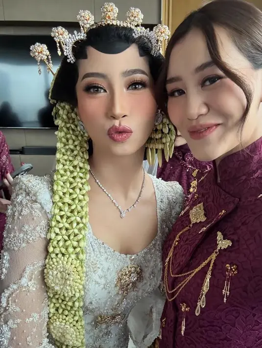 Melengkapi tampilannya dengan anting-anting emas. Wajahnya dipoles blush on coral dan lipstik pink. Rambutnya disanggul updo dengan poni panjang belah dua. [@aaliyahmassaid]