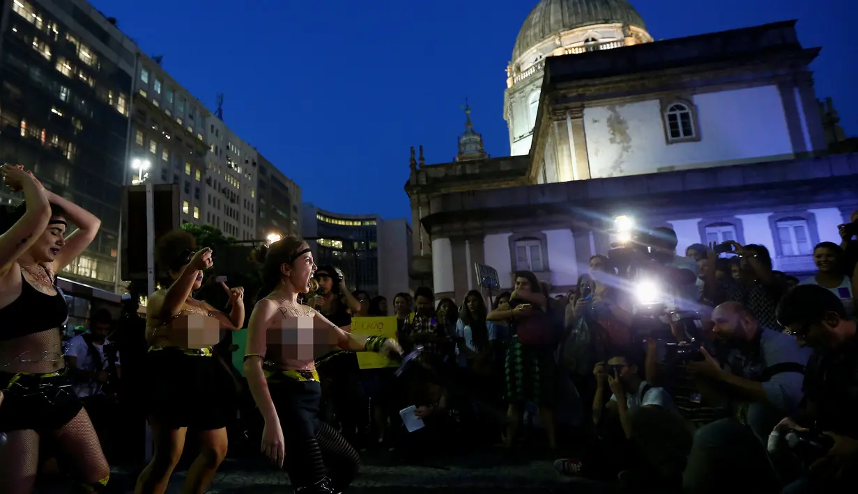 Sejumlah seniman wanita nekat bertelanjang dada saat menggelar demonstrasi di pusat kota Rio de Janeiro, Brasil, Rabu (1/6). Aksi dilakukan sebagai bentuk protes mereka terhadap maraknya kasus pemerkosaan dan kekerasan seksual. (REUTERS/Ricardo Moraes)