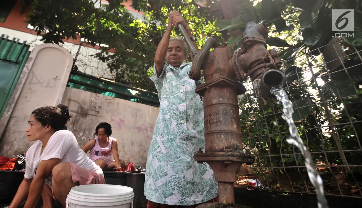 Warga menggunakan pompa air manual saat mencuci pakaian di pinggir jalan kawasan Kramat Pulo, Senen, Jakarta, Kamis (27/12). Para ibu ini mengaku harus bayar jika ingin buang air di WC umum yang berada di pemukiman. (Merdeka.com/Iqbal S. Nugroho)