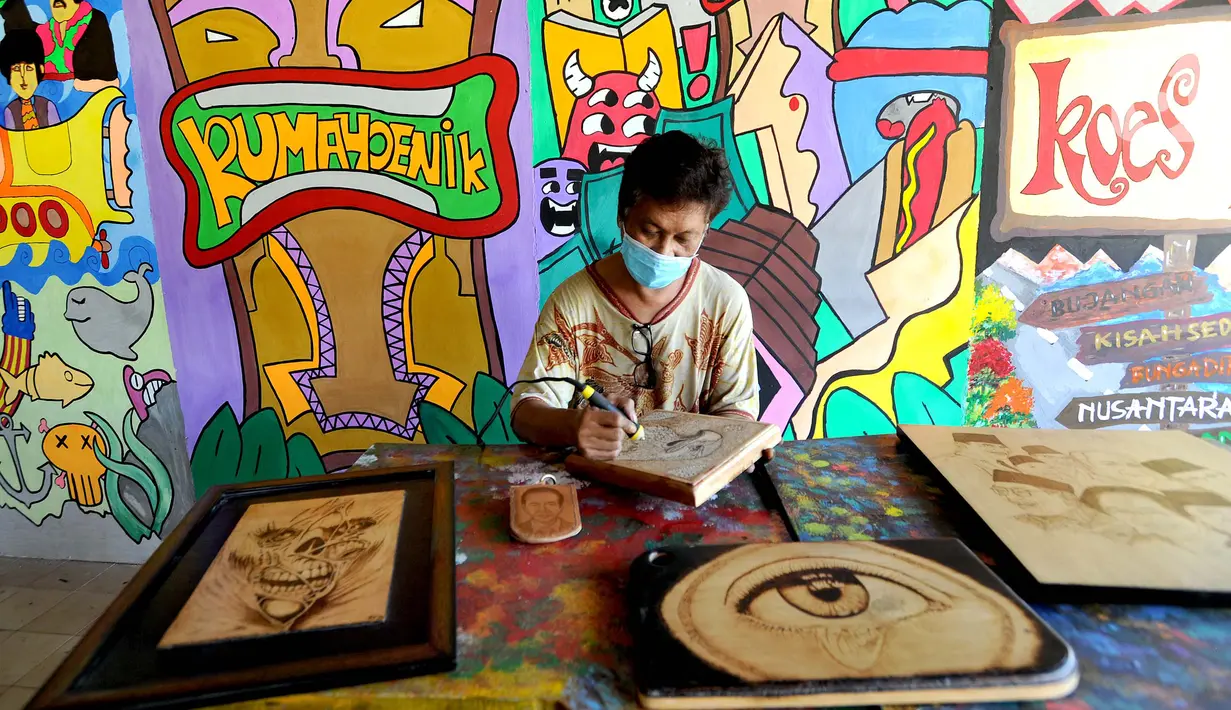 Arfan (55) menyelesaikan karya seni lukis bakar di galeri Rumah Oenik, Kampung Ragamukti, Tajur Halang, Bogor, Senin (28/9/2020). Arfan menjual karya seni lukis bakarnya dengan harga 300 ribu sampai jutaan rupiah dilihat dari besar dan tingkat kerumitannya. (merdeka.com/Arie Basuki)