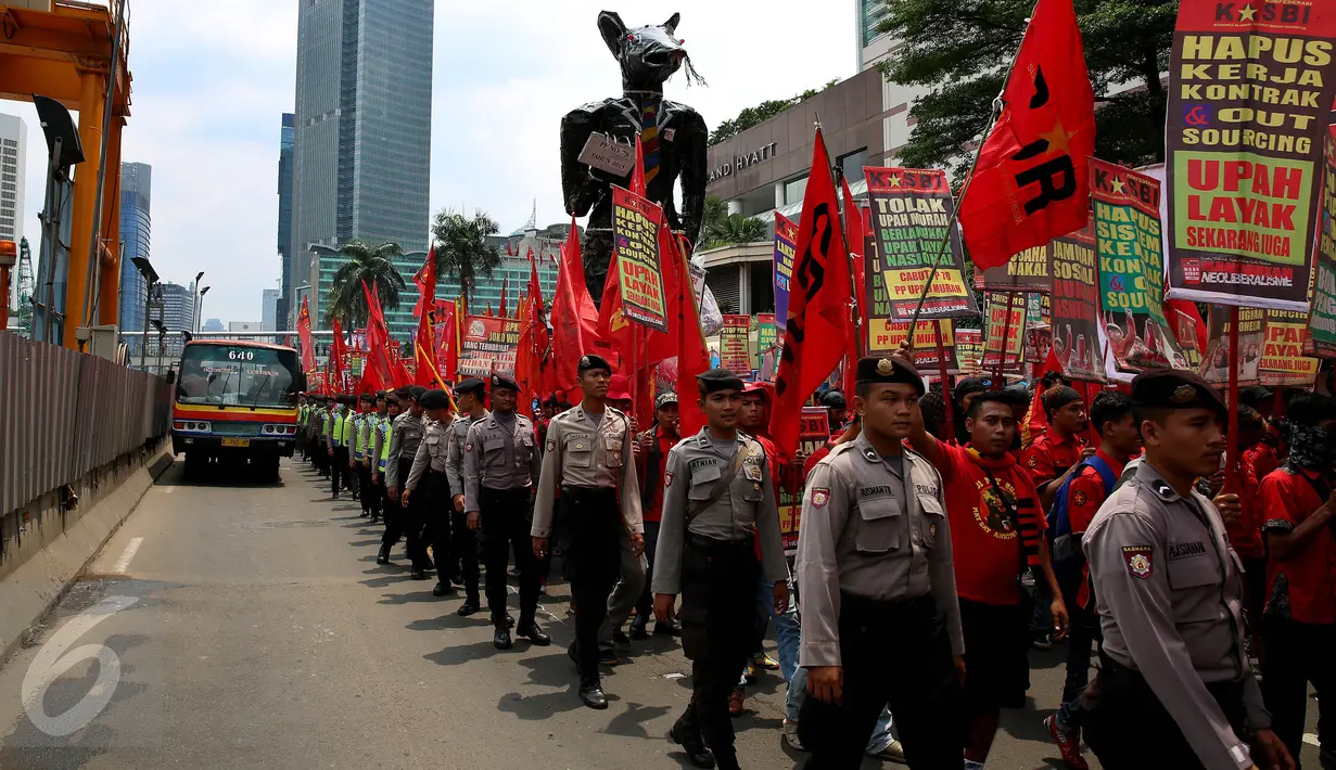 Petugas mengawal para buruh saat melakukan aksi long march menuju Istana Negara, Jakarta (31/10). Ratusan buruh meminta pemerintah mencabut PP Nomor 78 soal pengupahan yang dinilai tidak memperhatikan kesejahteraan para buruh. (Liputan6.com/Johan Tallo)